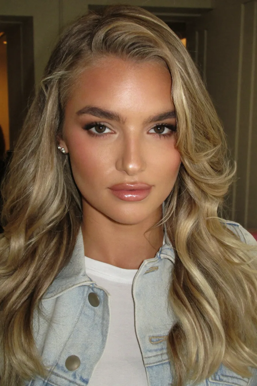 Voluminous Layered Shoulder-Length Blonde Waves with Side-Swept Bangs