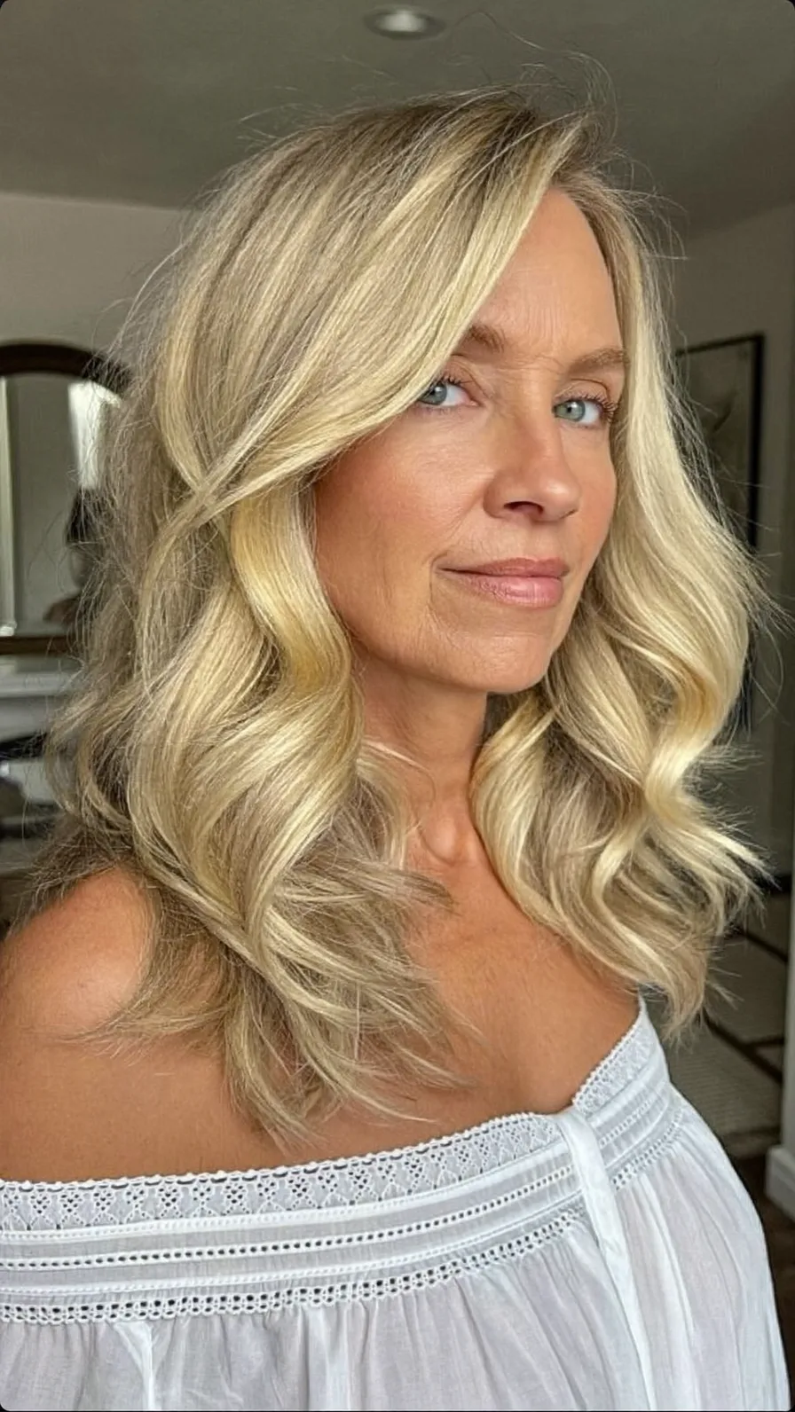 Voluminous Long Layered Blonde Waves with Side-Swept Bangs