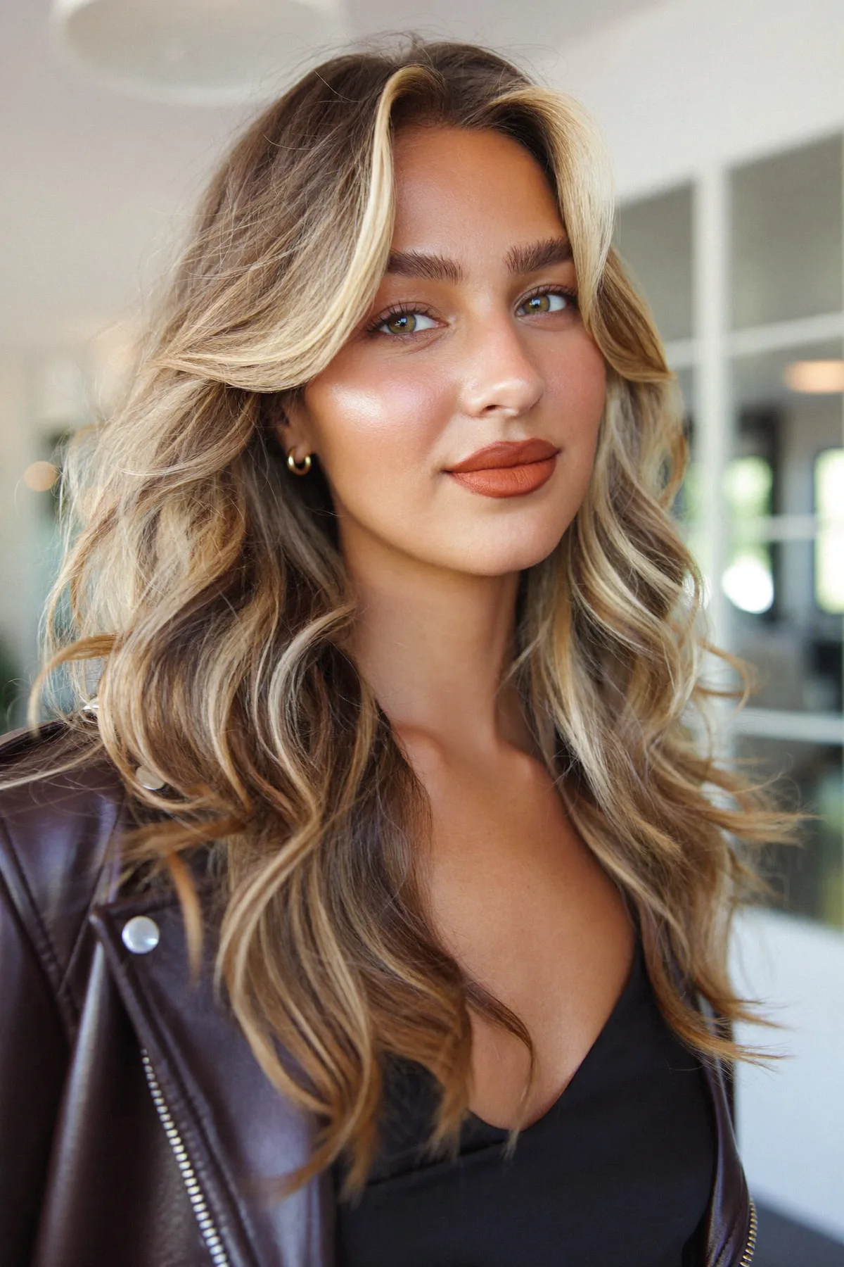 Caramel Bronde Balayage on Long Layered Mid-Back Waves with Curtain Bangs