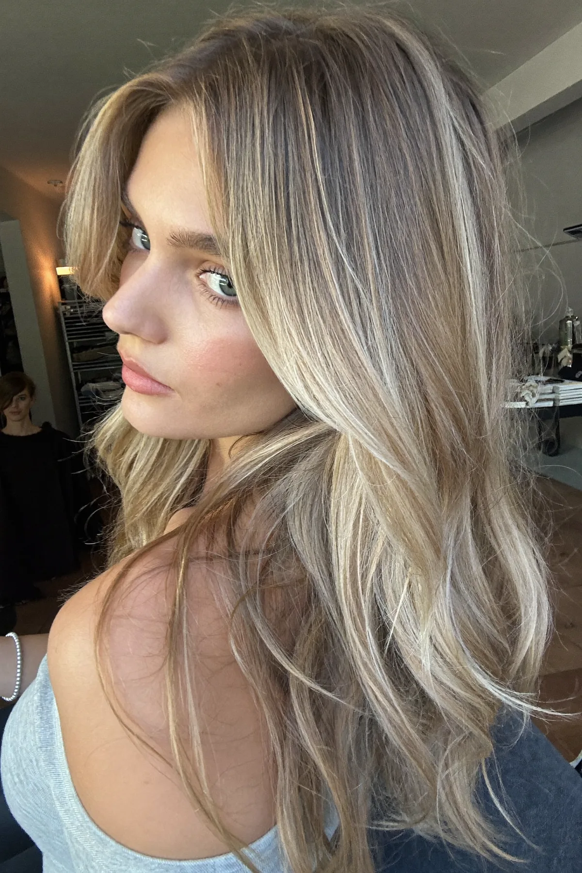 Caramel Bronde Balayage on Long Layered Mid-Back Waves with Curtain Bangs