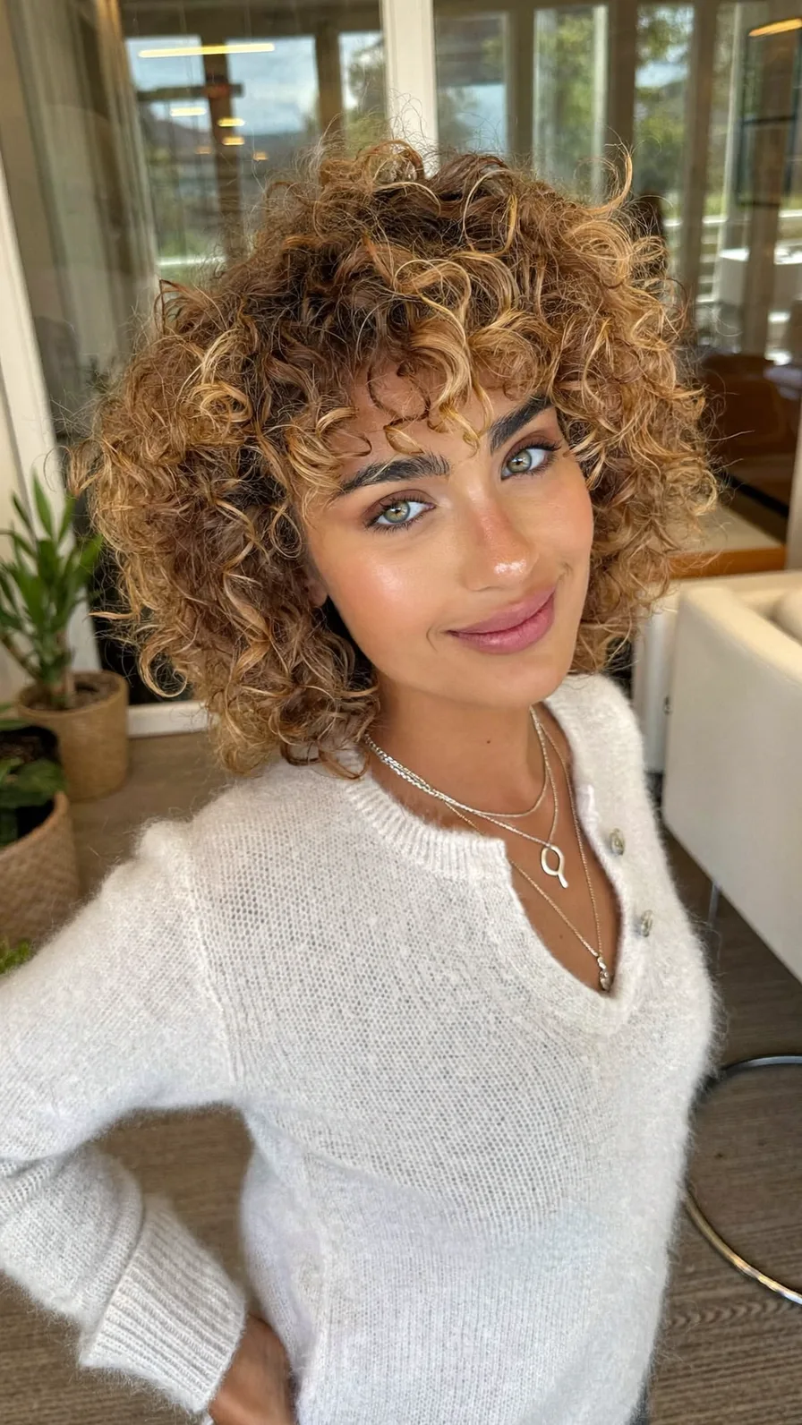 Voluminous Curly Bob with Warm Balayage and Curtain Bangs