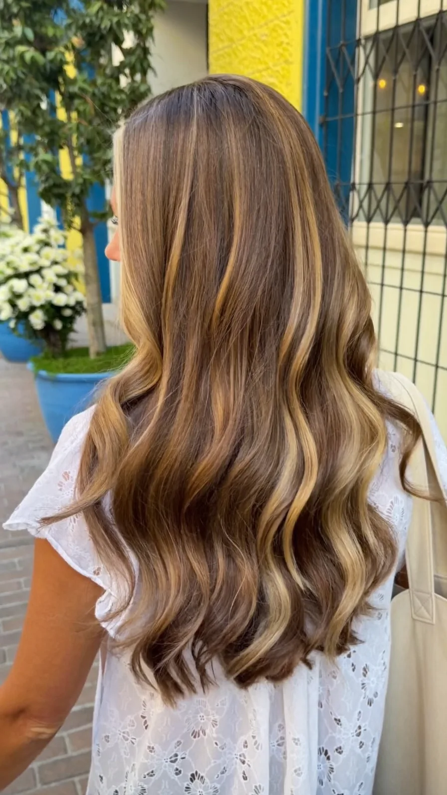 Long caramel balayage layers with flowing waves and rounded ends