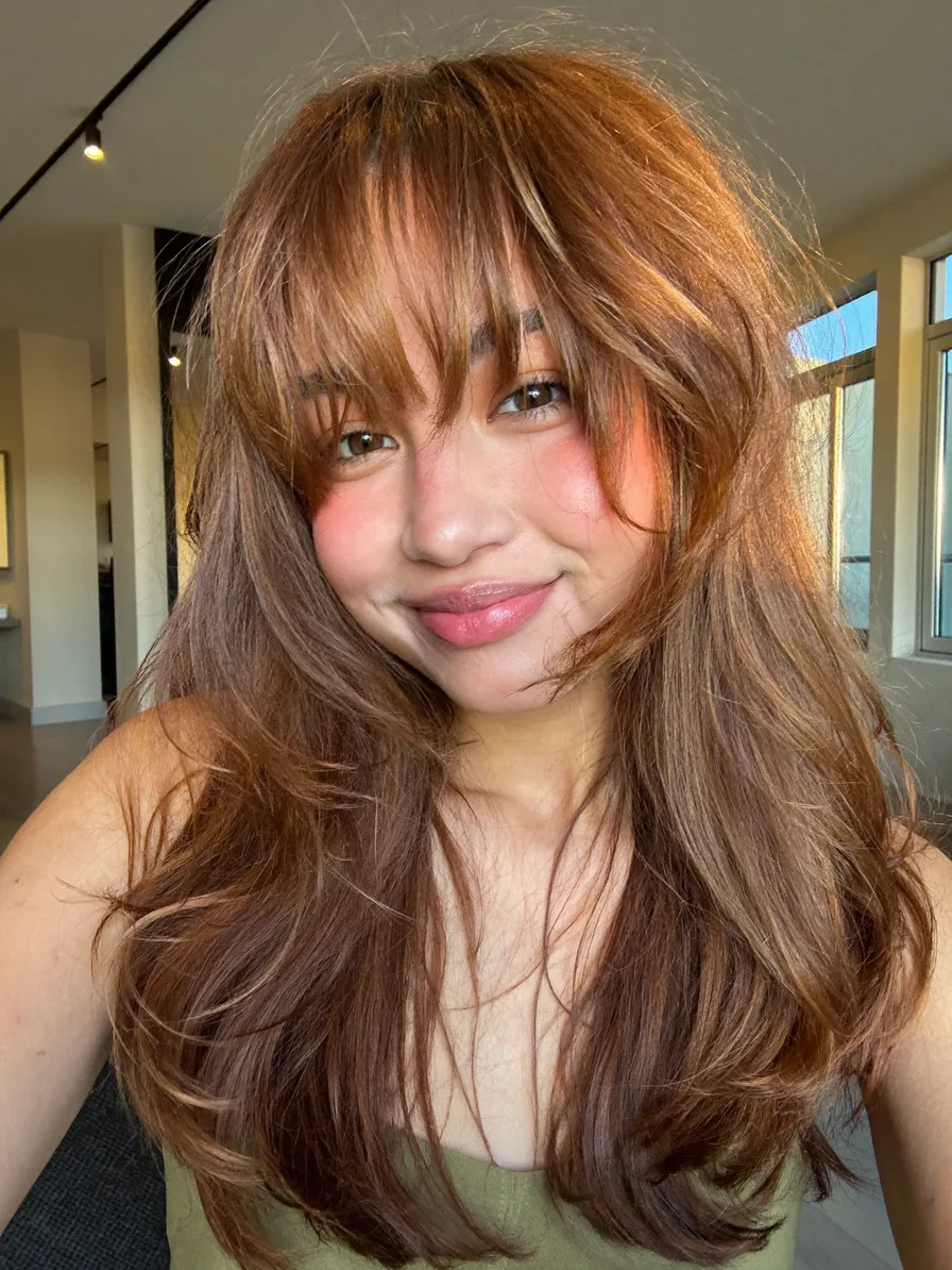 Voluminous Warm Caramel Brown Layered Hairstyle with Wispy Bangs