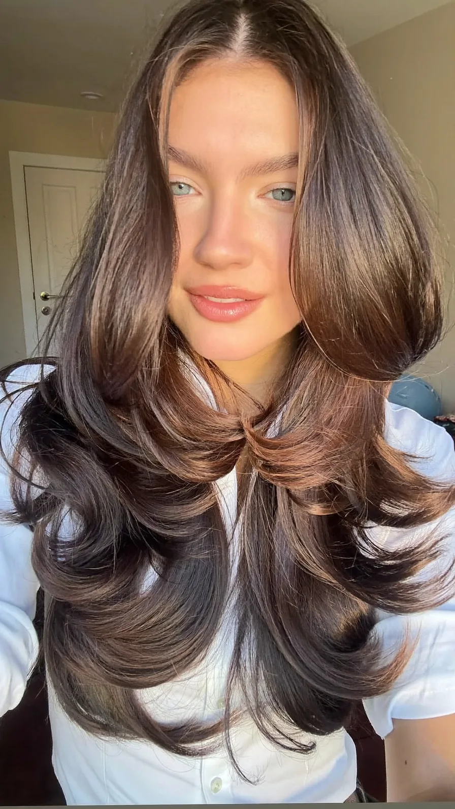 Voluminous Long Layers with Curtain Bangs and Flicked Ends
