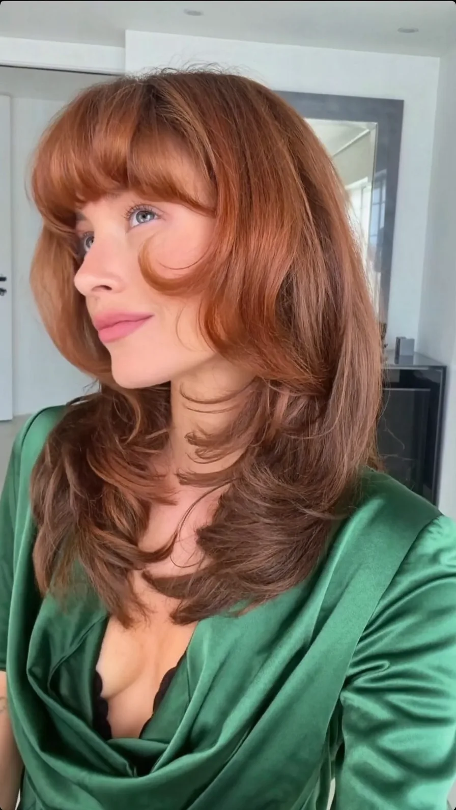 Medium length feathered layers with blunt bangs for volume