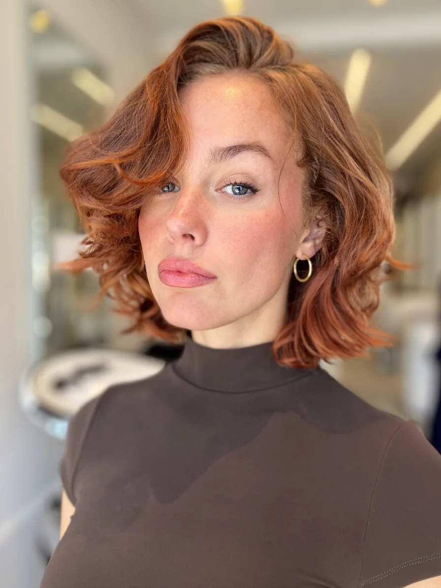 Voluminous Layered Copper Auburn Wavy Hairstyle with Side Bangs