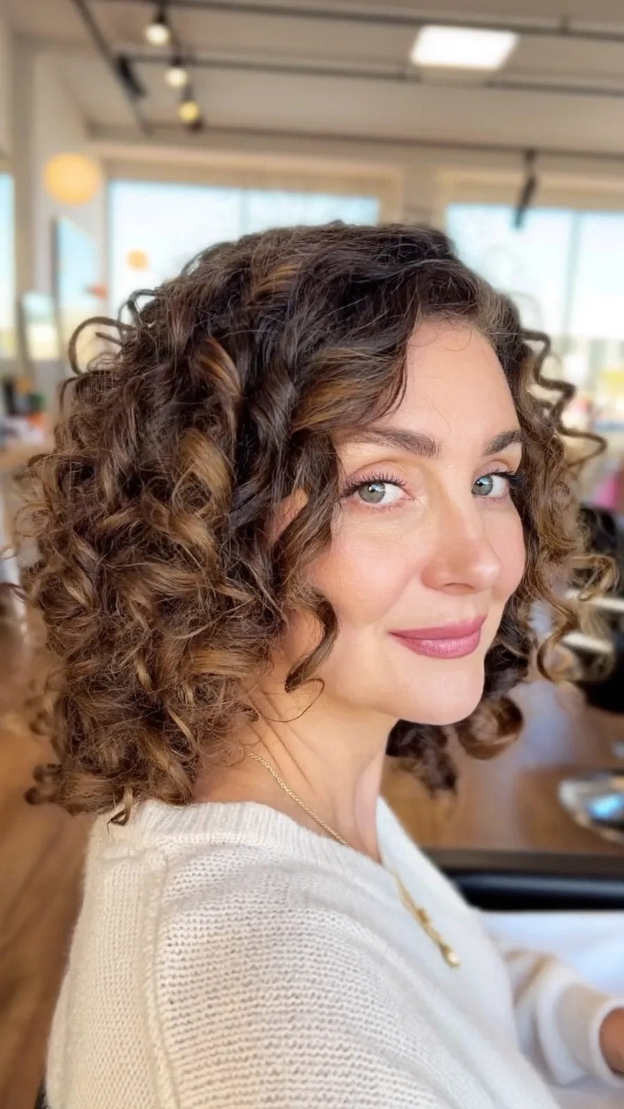 Voluminous Shoulder-Length Layered Curly Bob with Side-Swept Bangs