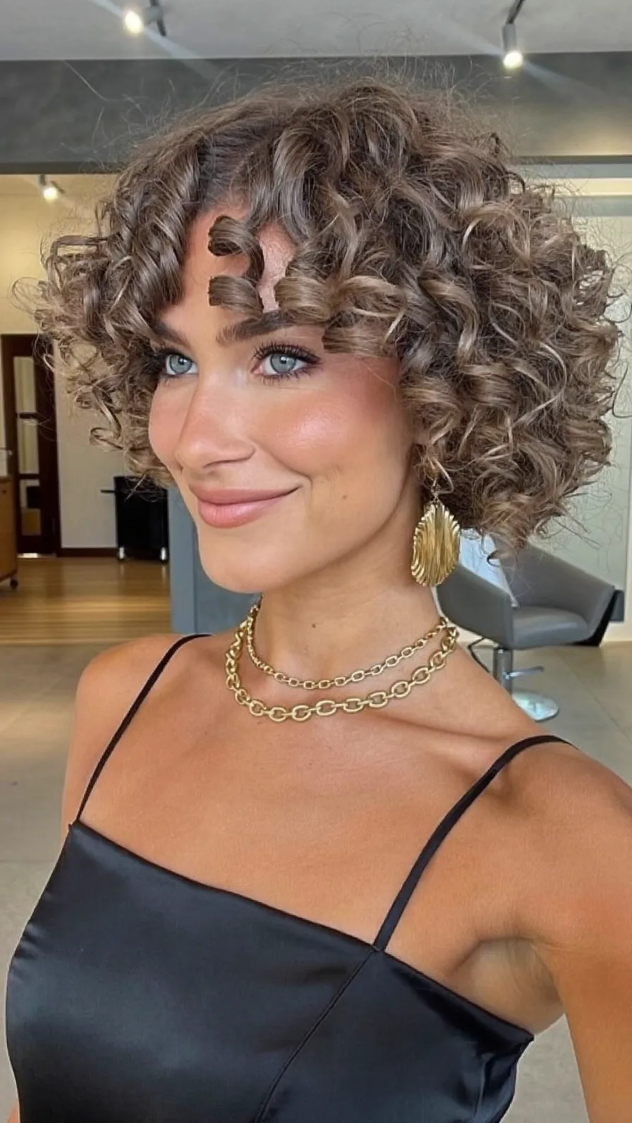 Voluminous Curly Bob with Curtain Bangs and Multi-Dimensional Highlights