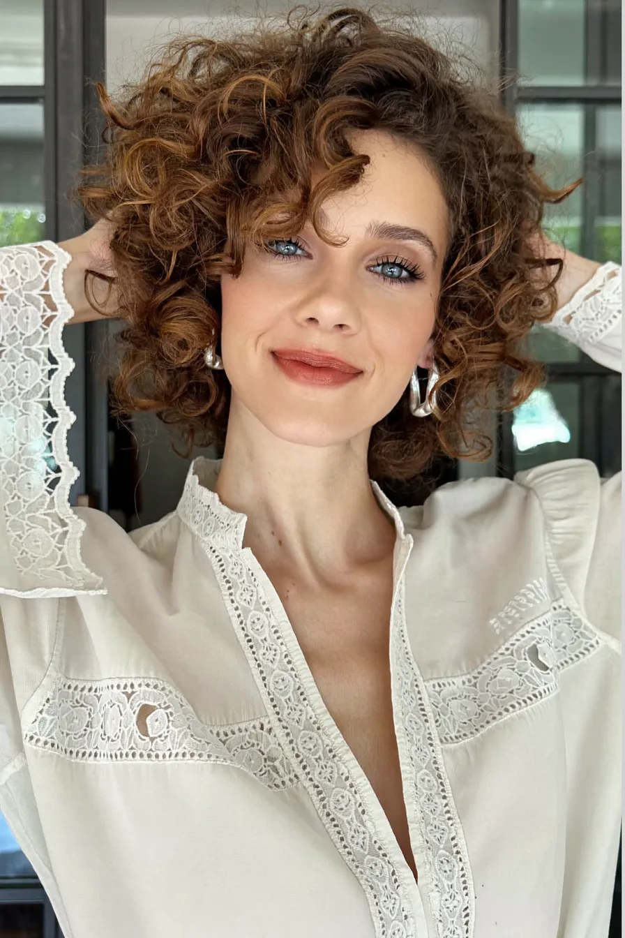 High-Volume Curly Bob with Side-Swept Bangs and Choppy Layers