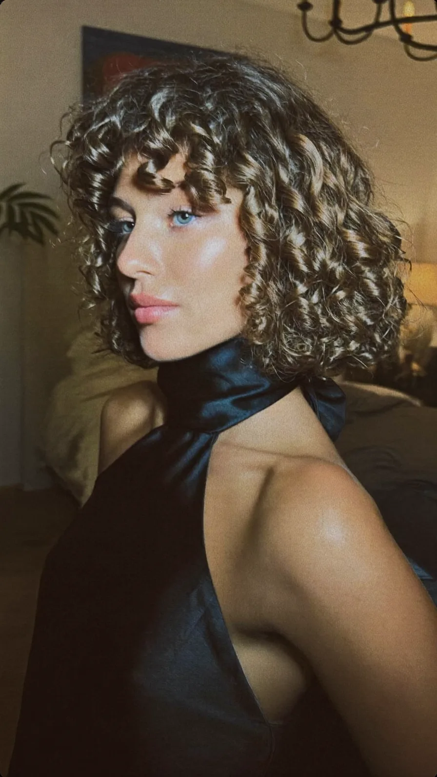 Voluminous Curly Bob with Curtain Bangs and Natural Highlights
