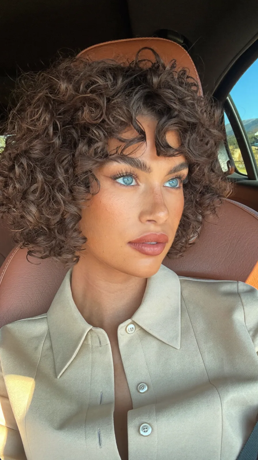 Voluminous Curly Bob with Bouncy Curly Bangs and Textured Layers