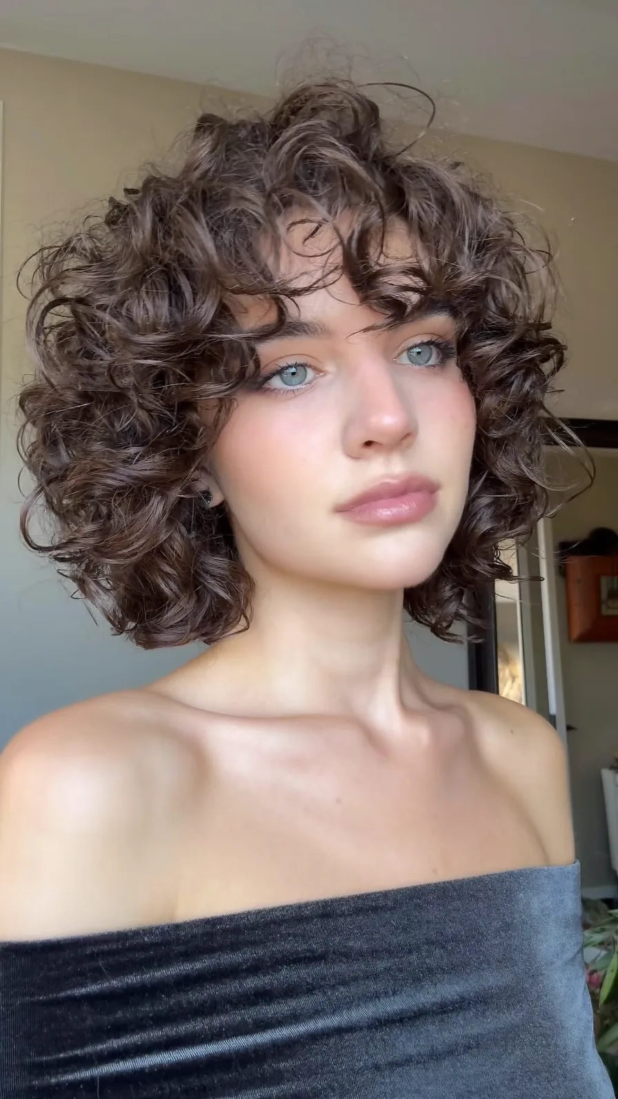 Voluminous Chin-Length Curly Bob with Textured Curtain Bangs