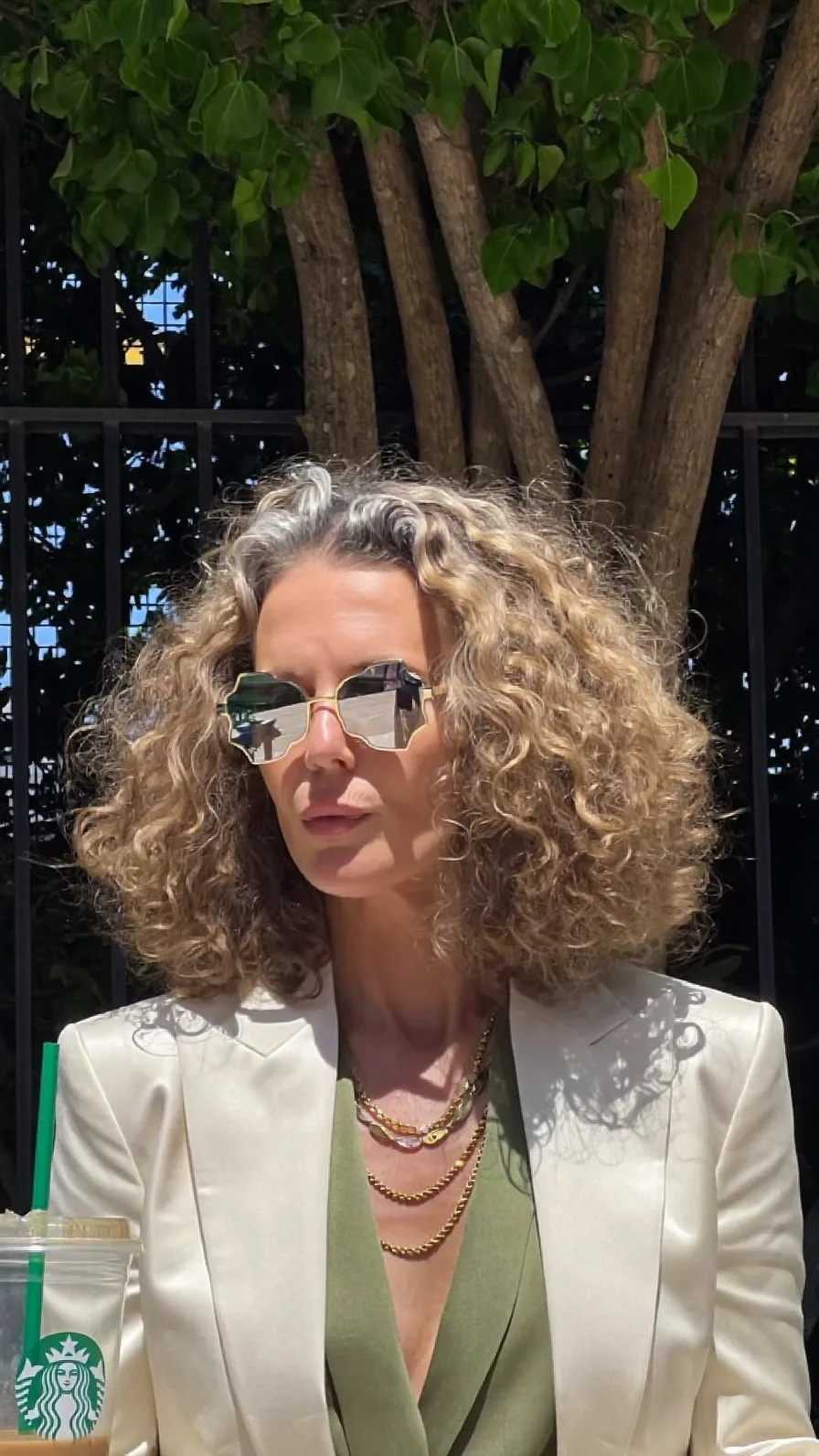 Voluminous Curly Shoulder-Length Layers with Natural Gray Highlights