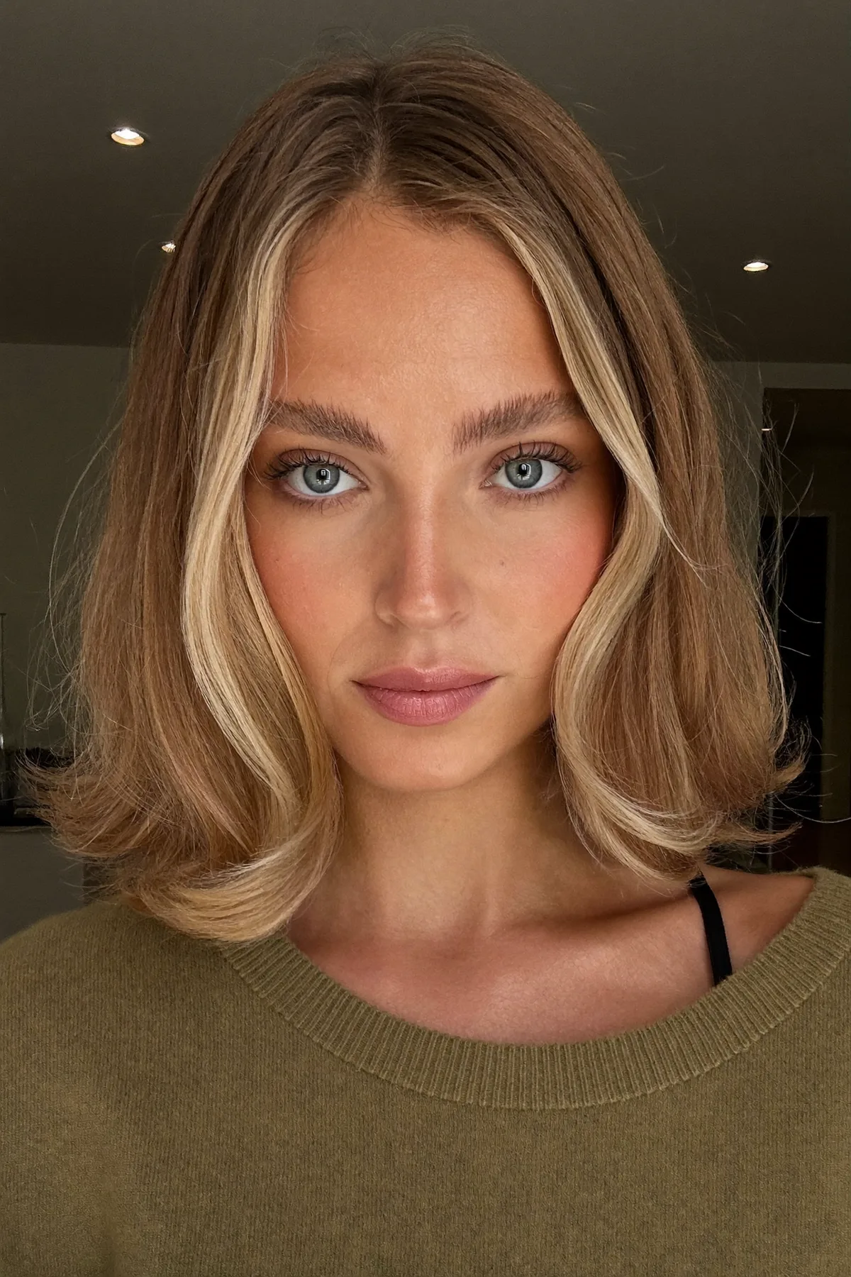 Chin-Length Dark Blonde Bob with Curtain Bangs and Money-Piece Highlights