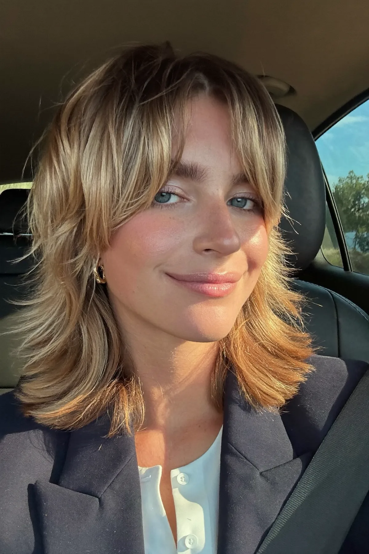 Shoulder-Length Dark Blonde Shag with Wavy Texture and Curtain Bangs