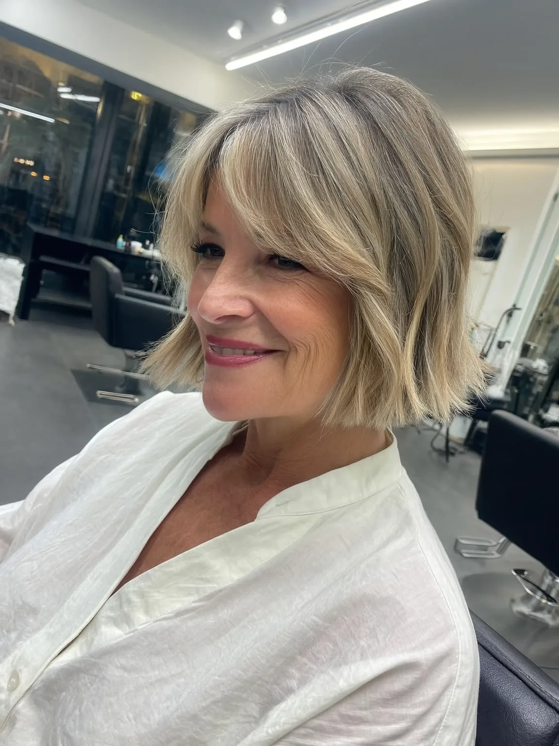 Wavy Sandy Blonde Bob with Ash Highlights and Curtain Bangs