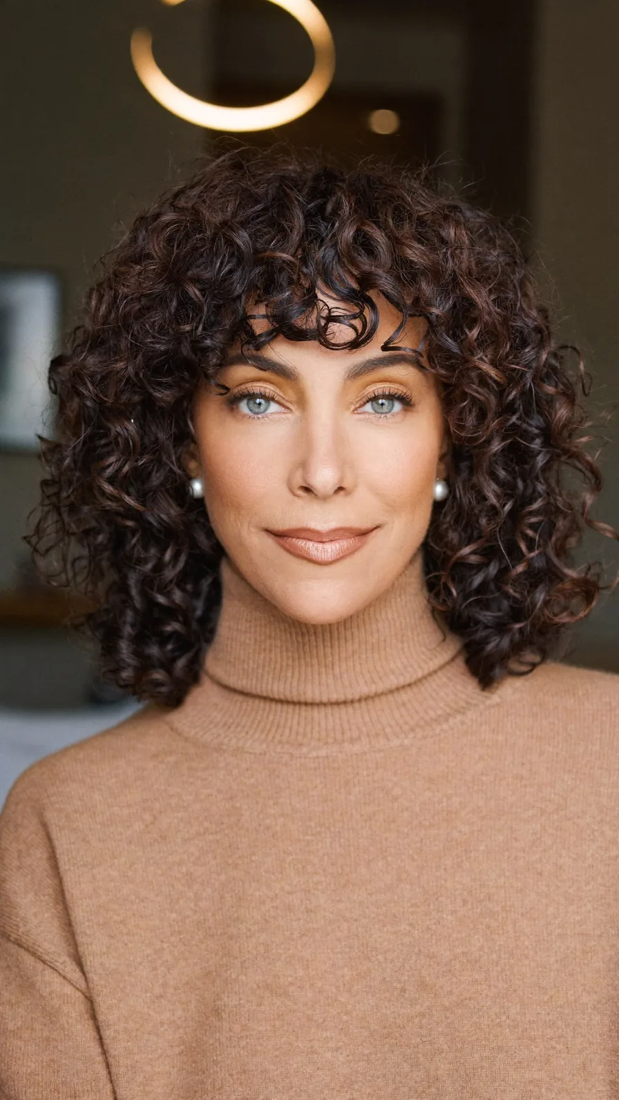 Voluminous Curly Bob with Natural Curtain Bangs for Oval Faces