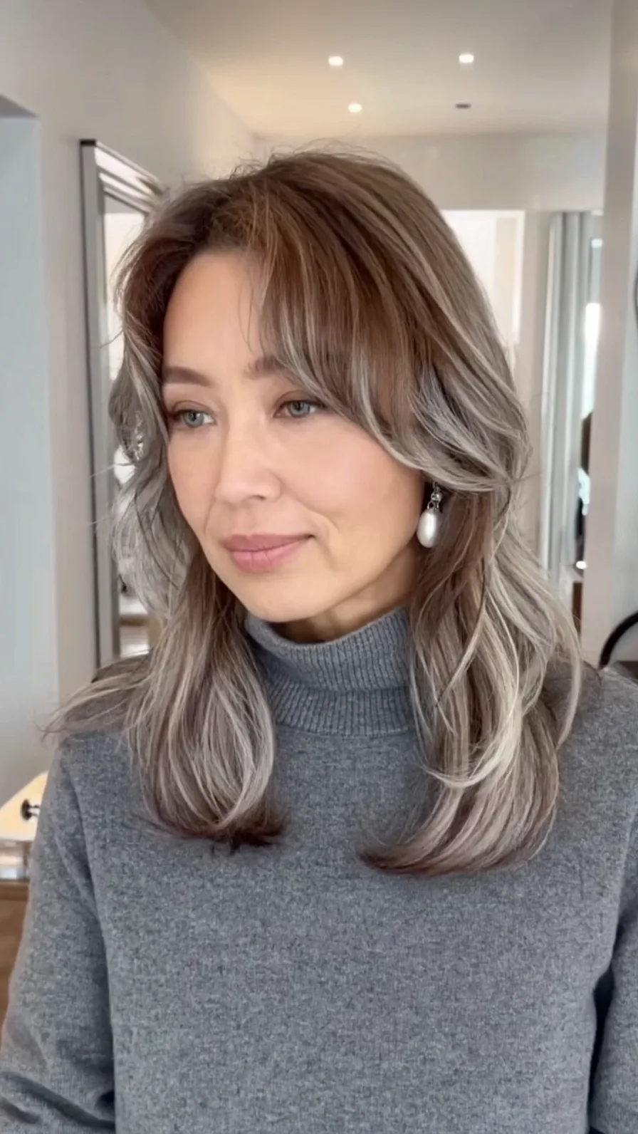 Elegant Shoulder-Length Brown Hair with Silver Highlights and Curtain Bangs