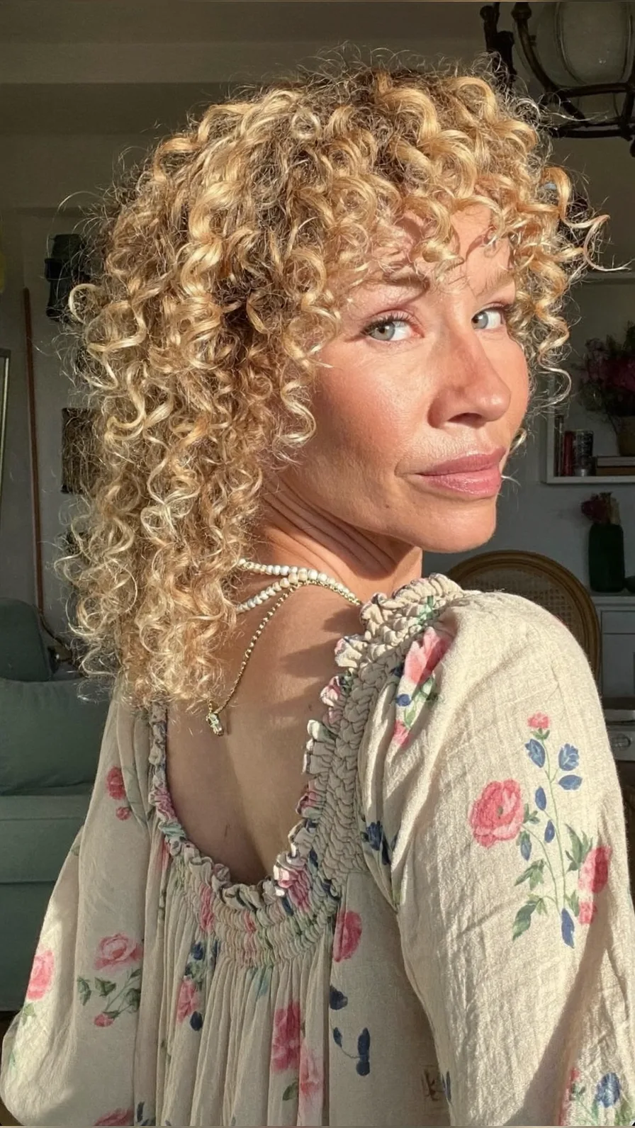 Voluminous Curly Blonde Locks with Curtain Bangs and Layers