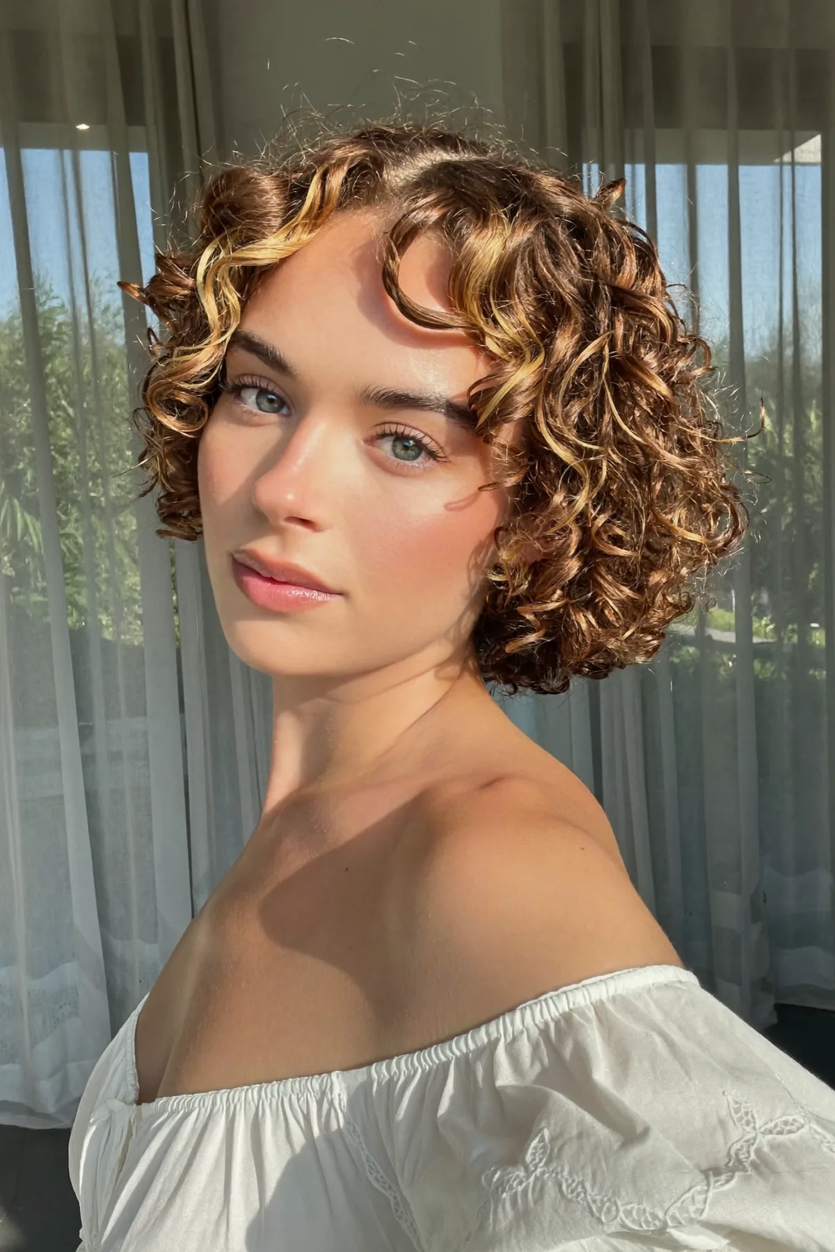Chin-Length Curly Natural Brunette Bob with Curtain Bangs and Chunky Highlights