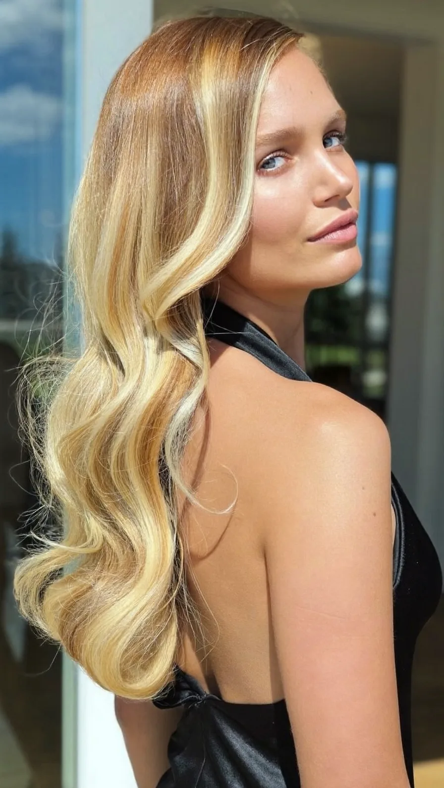 Voluminous long layered golden blonde waves with babylights