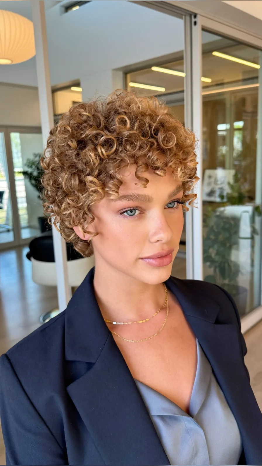 Voluminous Curly Pixie Cut with Warm Golden Brown Hue