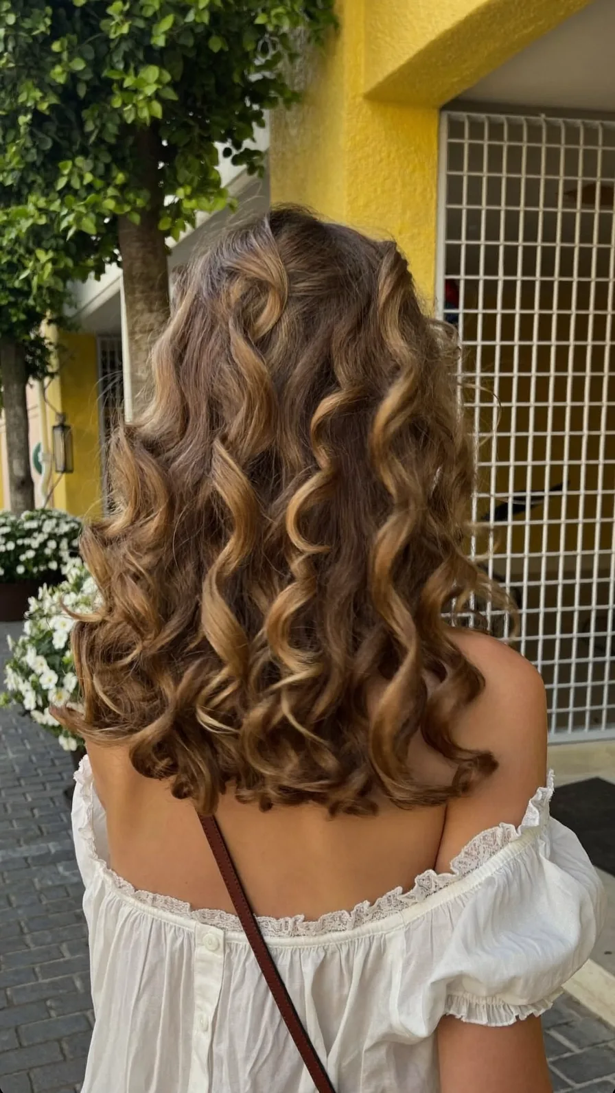 Voluminous Curly Shoulder-Length Honey Brown Balayage Style