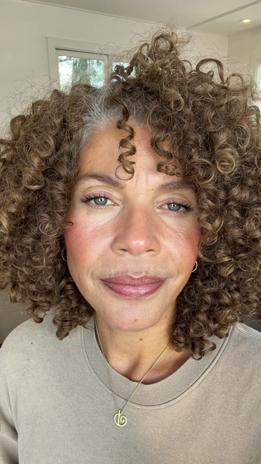 Voluminous Curly Layered Hairstyle with Natural Warm Tones