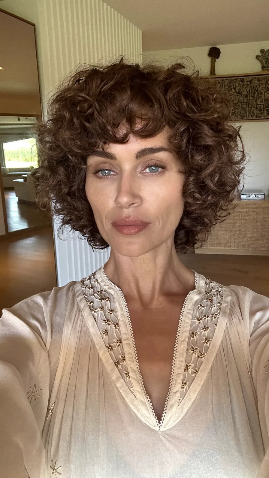 Voluminous Curly Chin-Length Layered Hair with Curtain Bangs