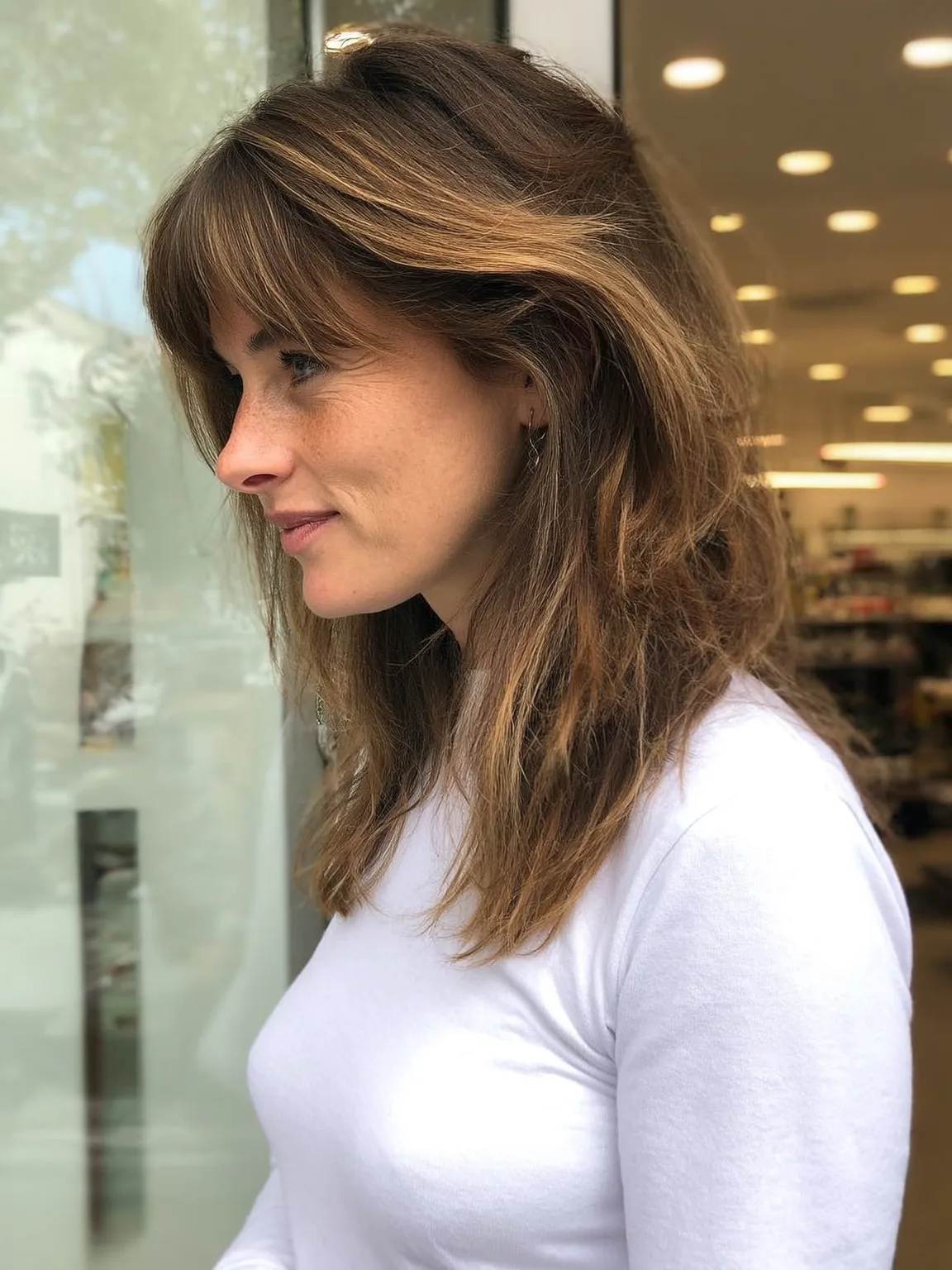 Medium-Length Honey Blonde Balayage Wavy Layers with Curtain Bangs