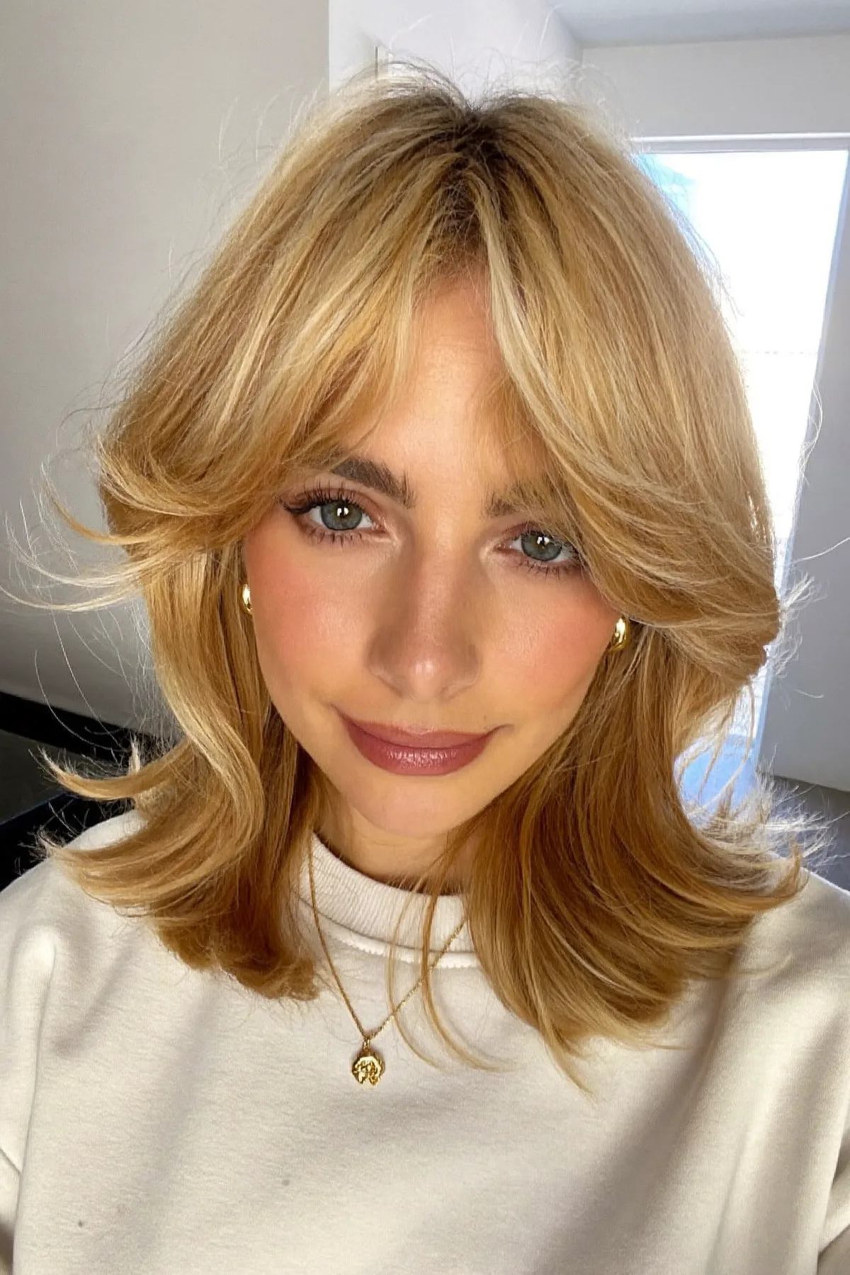 Honey Golden Blonde Shoulder-Length Lob with Curtain Bangs and Waves