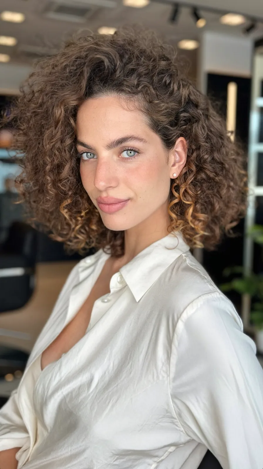 Chin-Length Layered Curly Bob with Honey Blonde Highlights