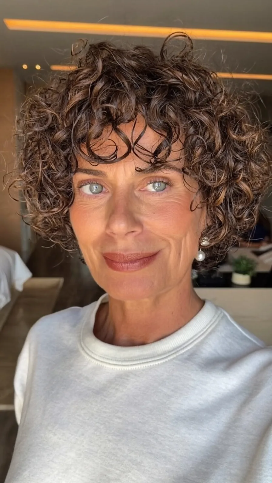 Voluminous Curly Bob with Curtain Bangs and Subtle Highlights