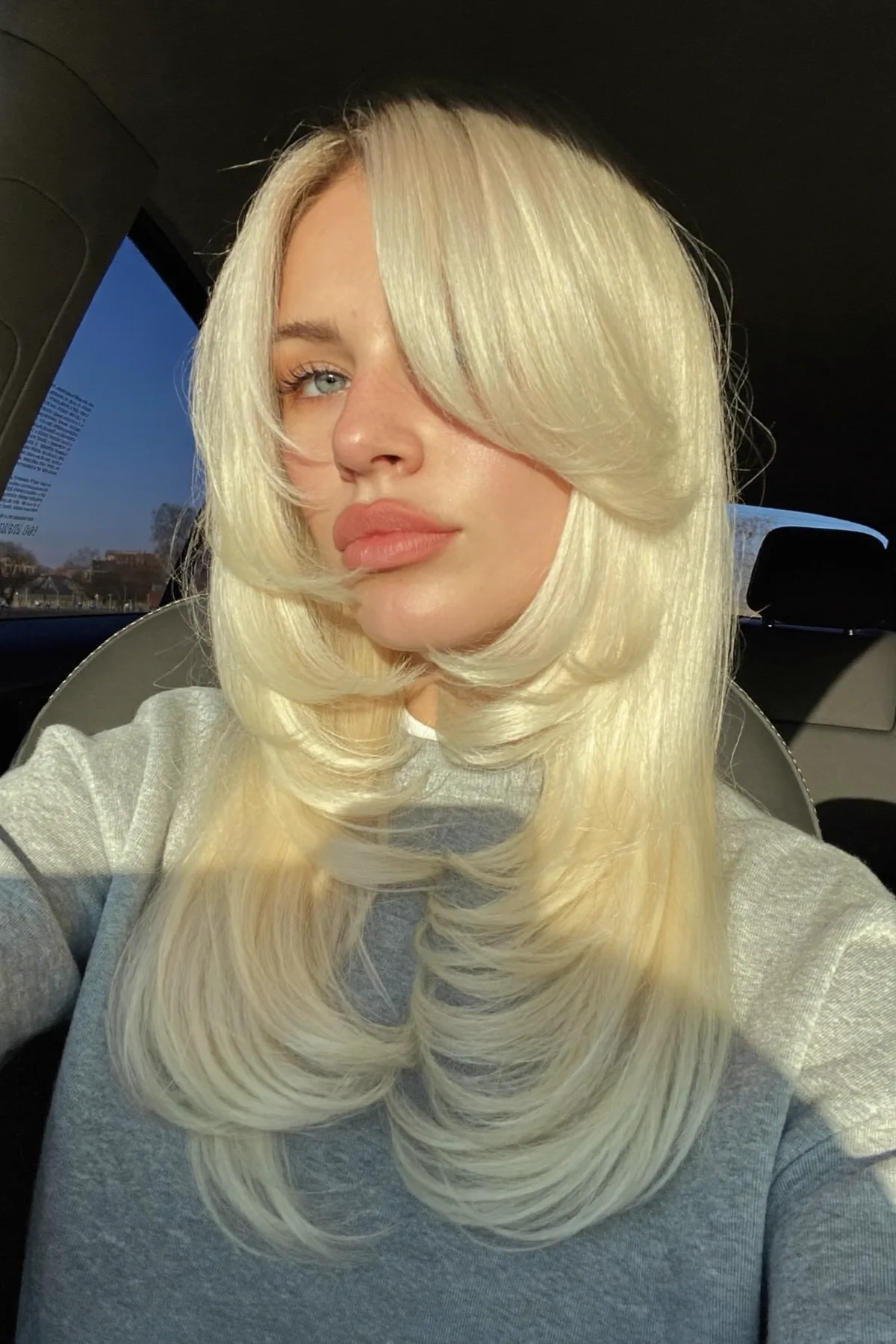 Sleek Platinum Ash Blonde Long Layered Cut with Curtain Bangs
