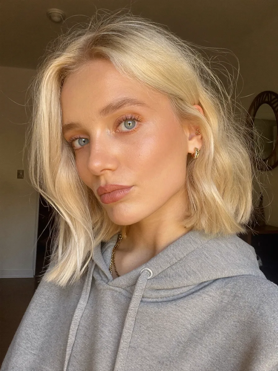 Shoulder-Length Wavy Platinum Blonde Hair with Curtain Bangs