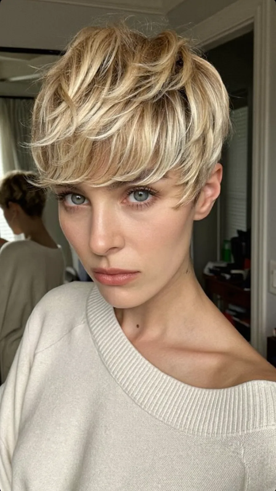 Voluminous Textured Platinum Blonde Pixie with Side-Swept Bangs