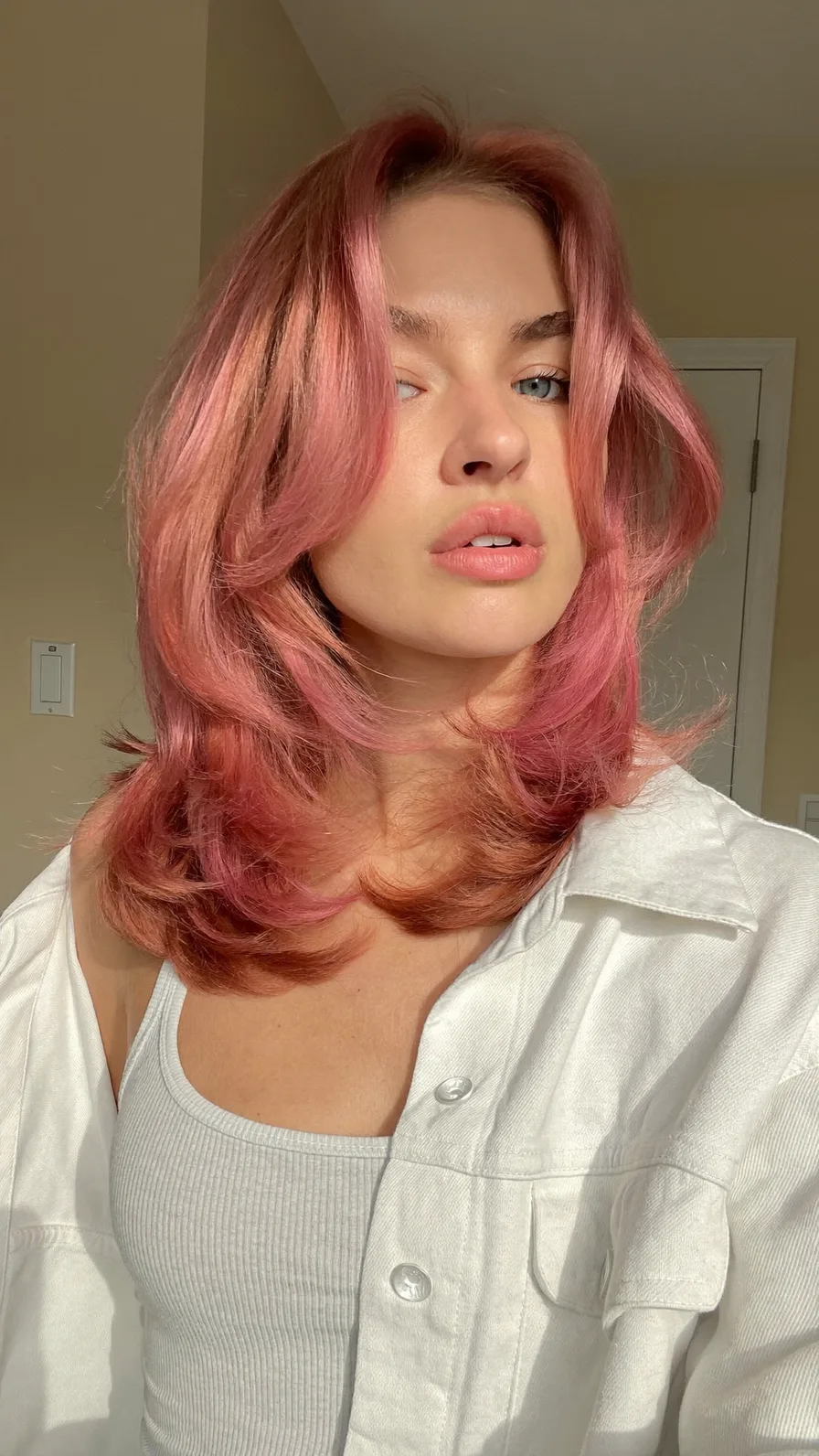 Medium Length Rose Gold Hair with Curtain Bangs and Flicked Ends