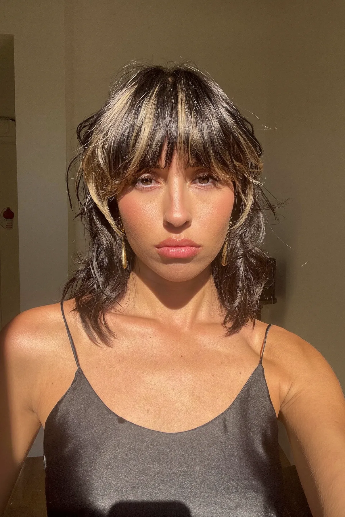 Jet Black Collarbone-Length Shag with Full Fringe and Chunky Highlights