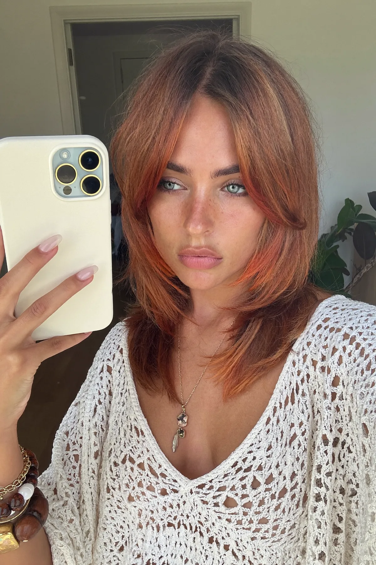 Shoulder-Length Strawberry Blonde Shag with Wavy Curtain Bangs