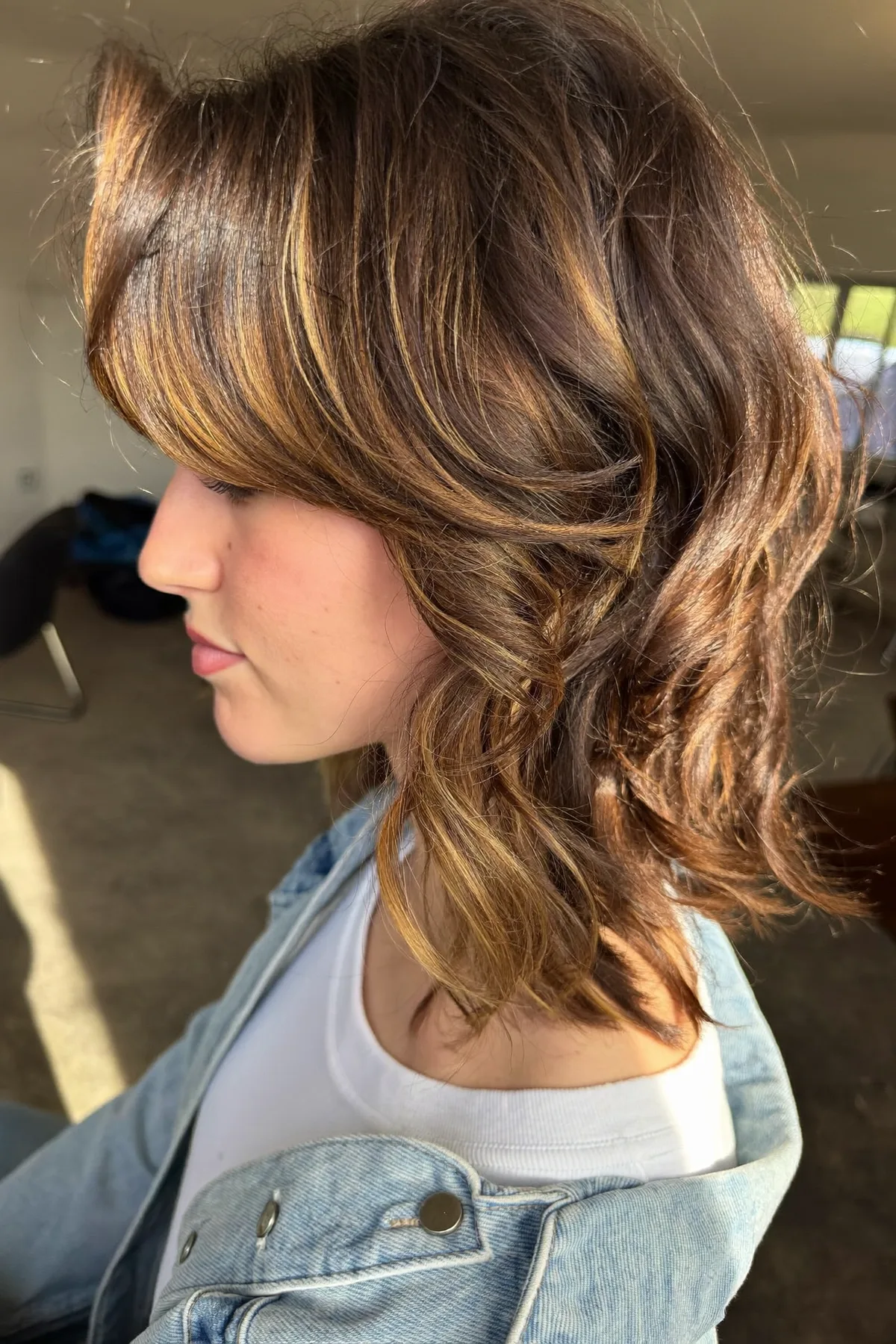 Natural Brunette Shoulder-Length Shag with Curtain Bangs and Chunky Highlights
