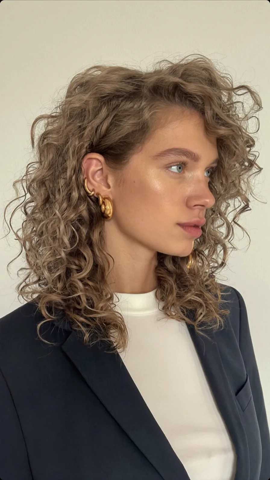 Voluminous Curly Shoulder-Length Layered Hairstyle with Side Parting