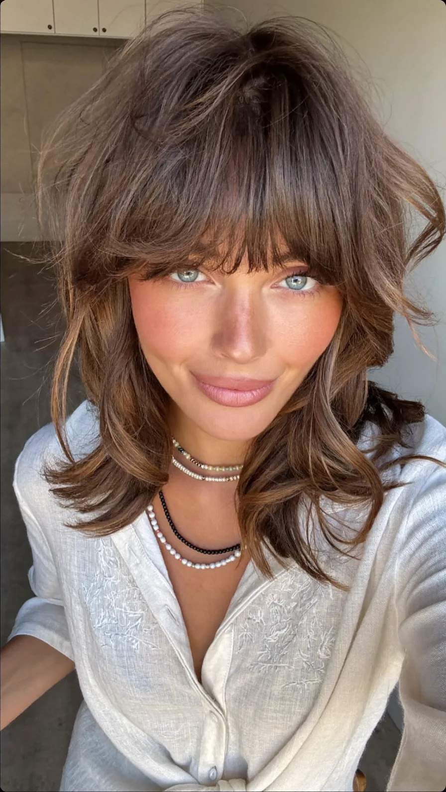 Voluminous Shoulder-Length Hair with Curtain Bangs & Balayage Highlights