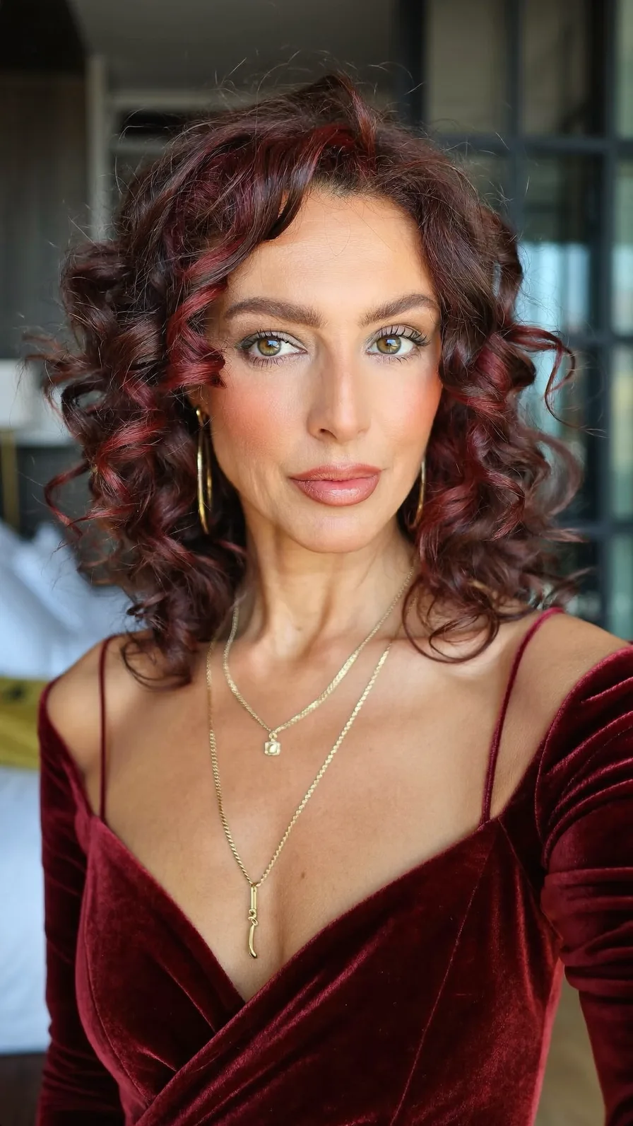 Voluminous Shoulder-Length Curly Burgundy Hair with Side Sweep