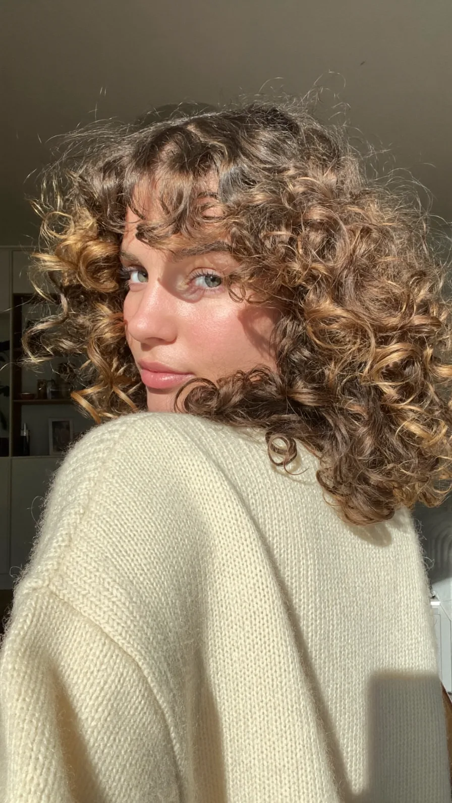Voluminous Curly Shoulder-Length Hair with Warm Honey Balayage
