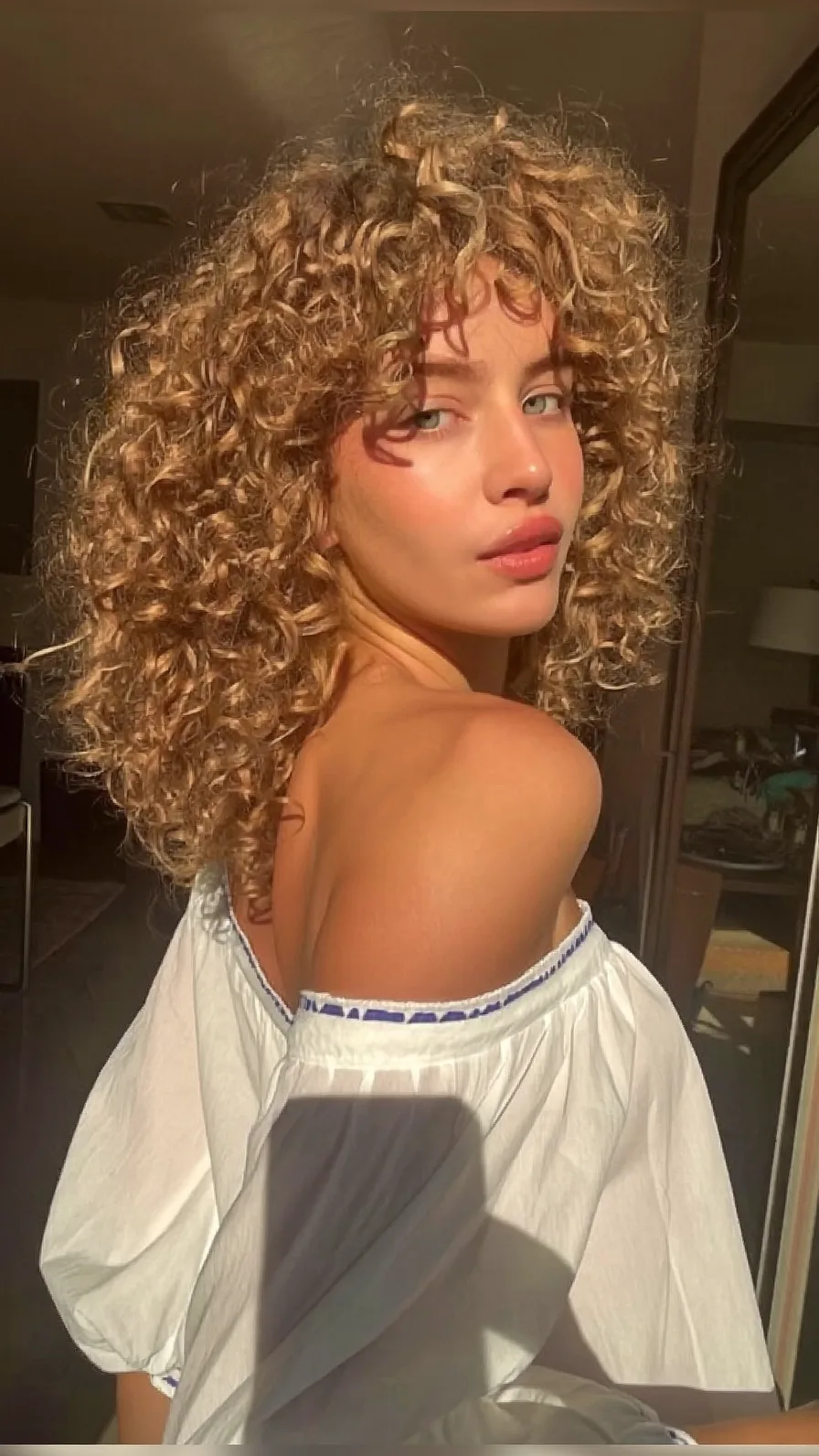 Voluminous Shoulder-Length Curly Hair with Curtain Bangs