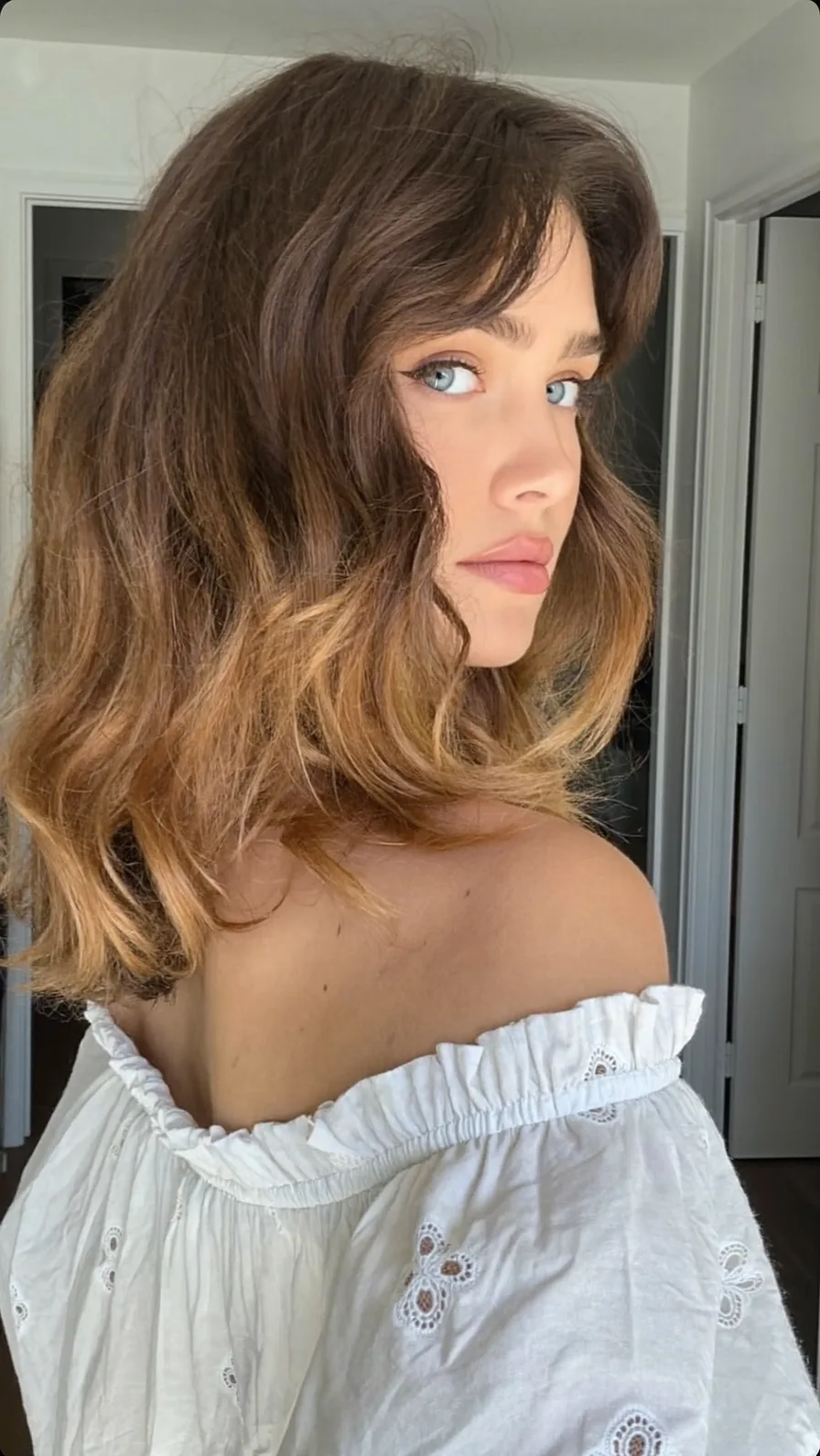 Shoulder-Length Wavy Hair with Honey Blonde Balayage and Curtain Bangs
