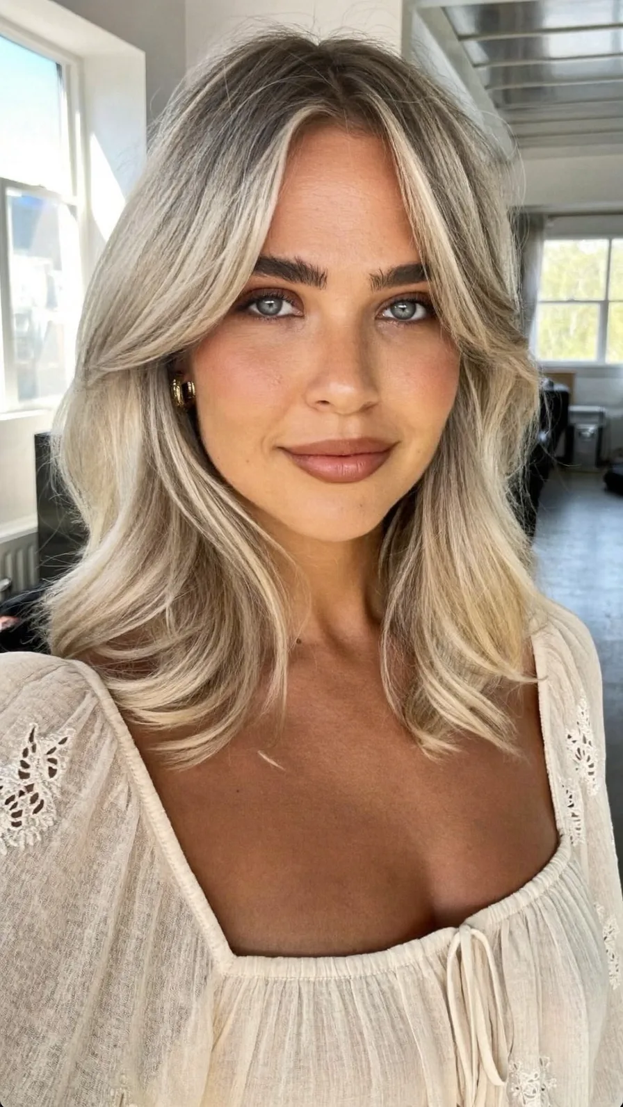 Shimmering Ash Blonde Long Layers with Curtain Bangs