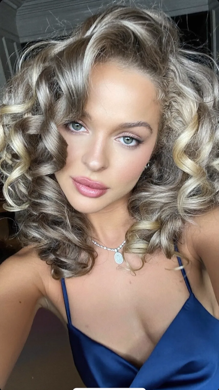 Voluminous Layered Shoulder-Length Curly Hair with Blonde Highlights