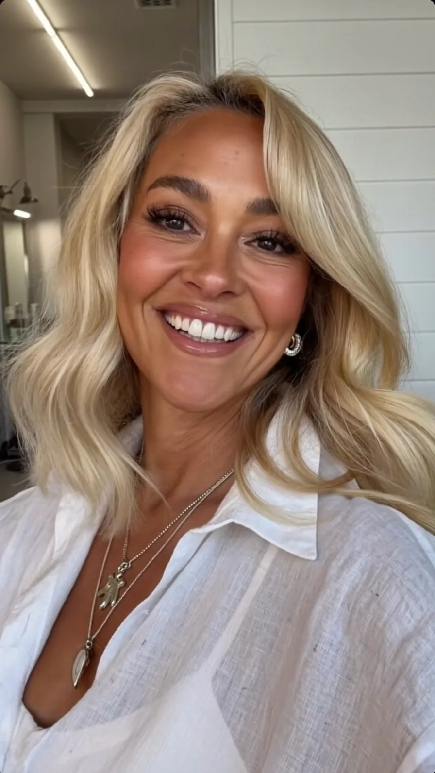 Voluminous Shoulder-Length Warm Blonde Hairstyle with Side-Swept Bangs