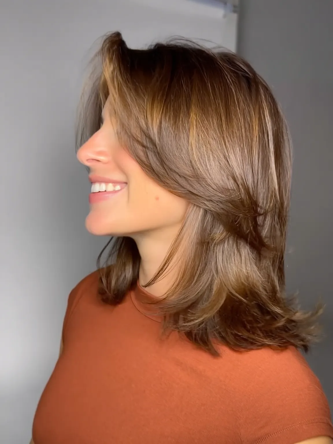 Shoulder-Length Wavy Layers with Side-Swept Caramel Bangs